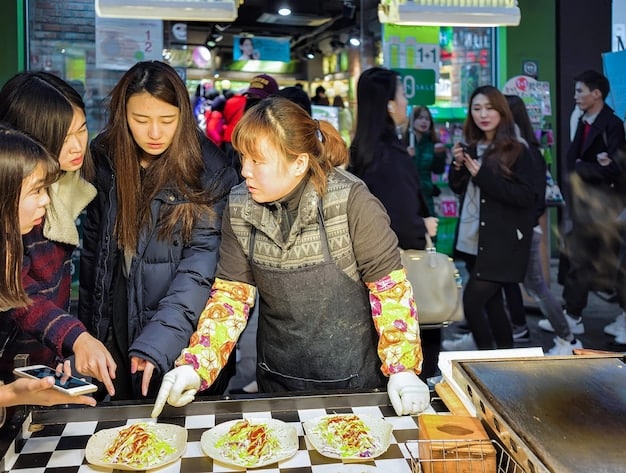 People trying out dishes at a Korean food stall, and trying on Korean dresses.