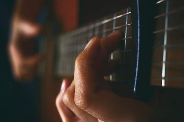 A person's hand holding a guitar pick and strumming the strings of an acoustic guitar. The focus is on the strumming motion and the clarity of the sound produced.