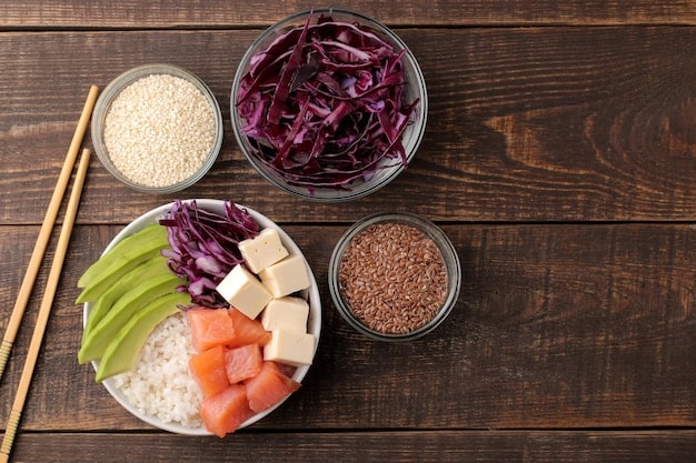 A photograph displaying the ingredients neatly arranged for making Bibimbap at home, including cooked rice, an assortment of colorful vegetables (carrots, spinach, cucumbers, bean sprouts), seasoned ground beef, a fried egg, and a bottle of gochujang. The ingredients are placed on a clean kitchen counter, ready to be assembled into the dish.